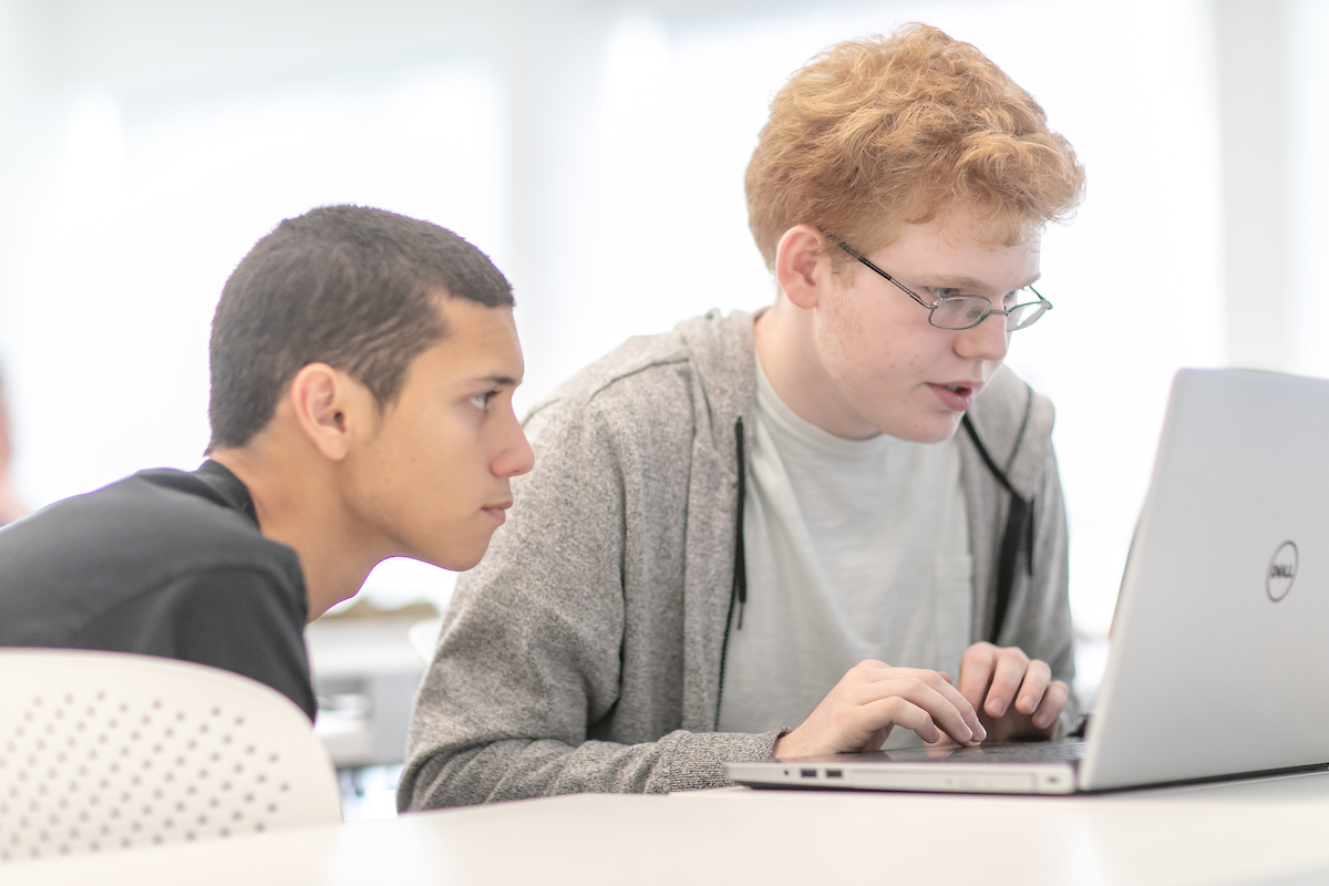 Two male students look at computer