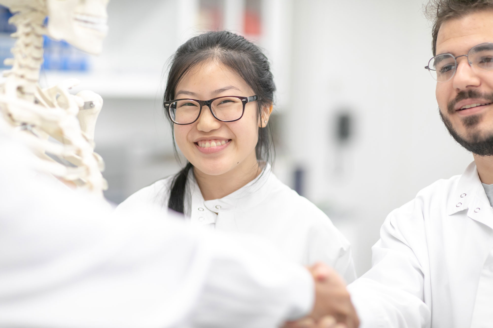 students smiling in lab coats
