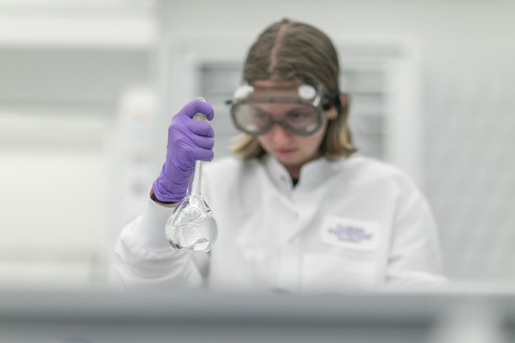 female student looks at lab equipment