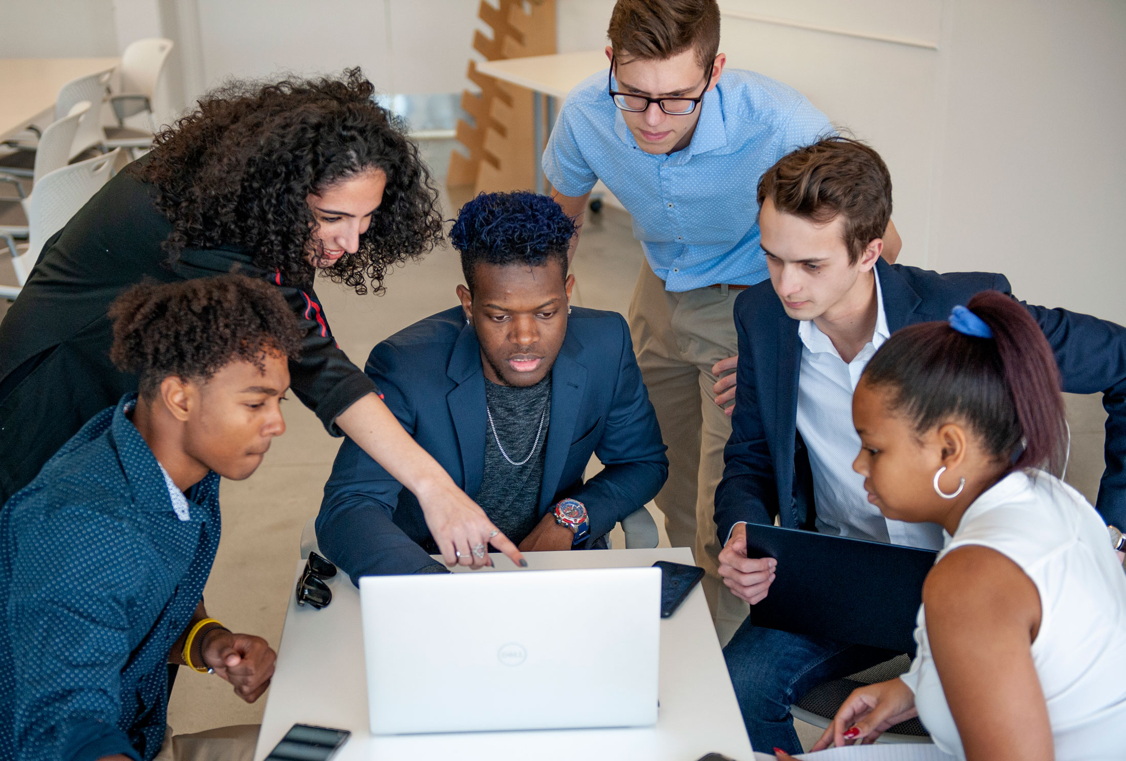 Students collaborate around a computer