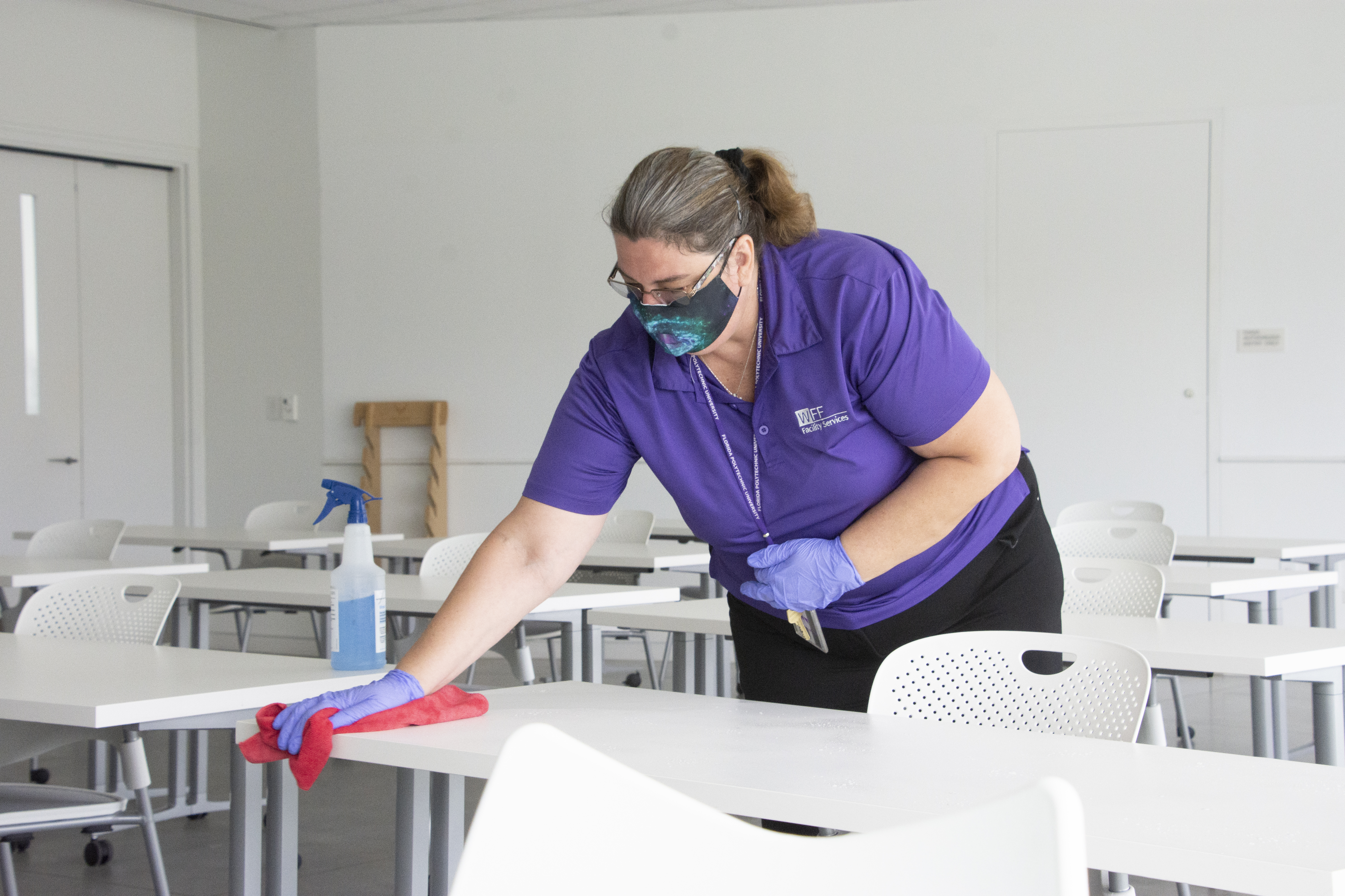 Female cleaning a desk.