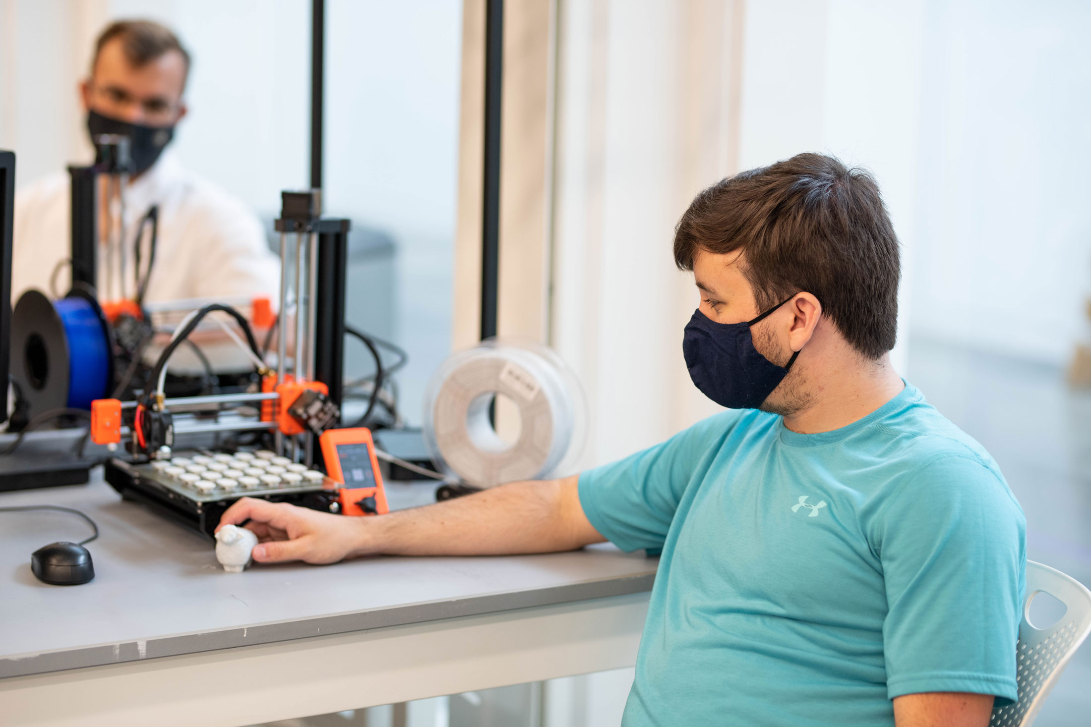 Graduate student Colton Frears examines an object created with the new Prusa 3D printers on campus. 