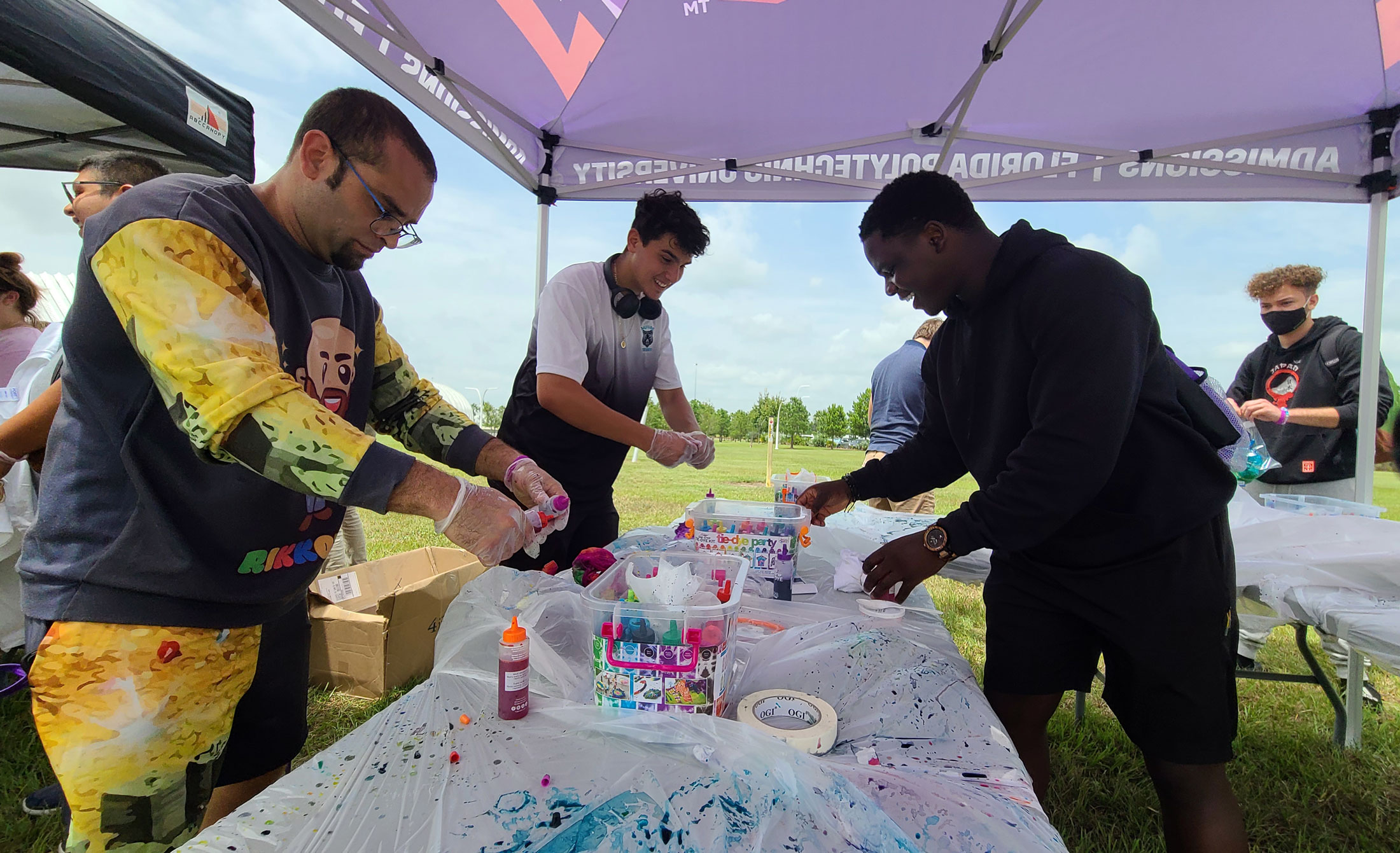 A group of students takes part in a Purple Fire Week tie-dye activity.