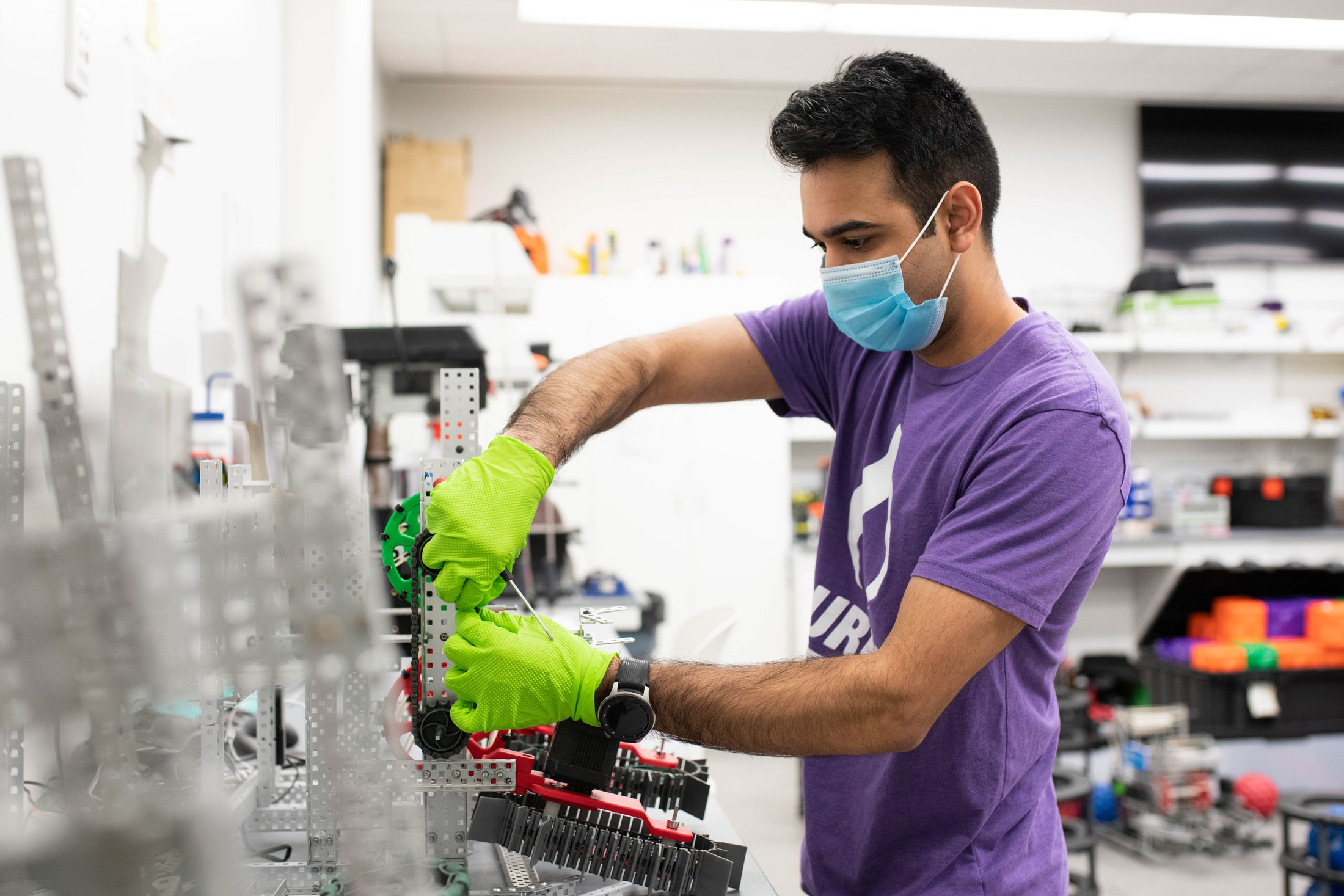 Mihir Lad works on a VEX U robot.