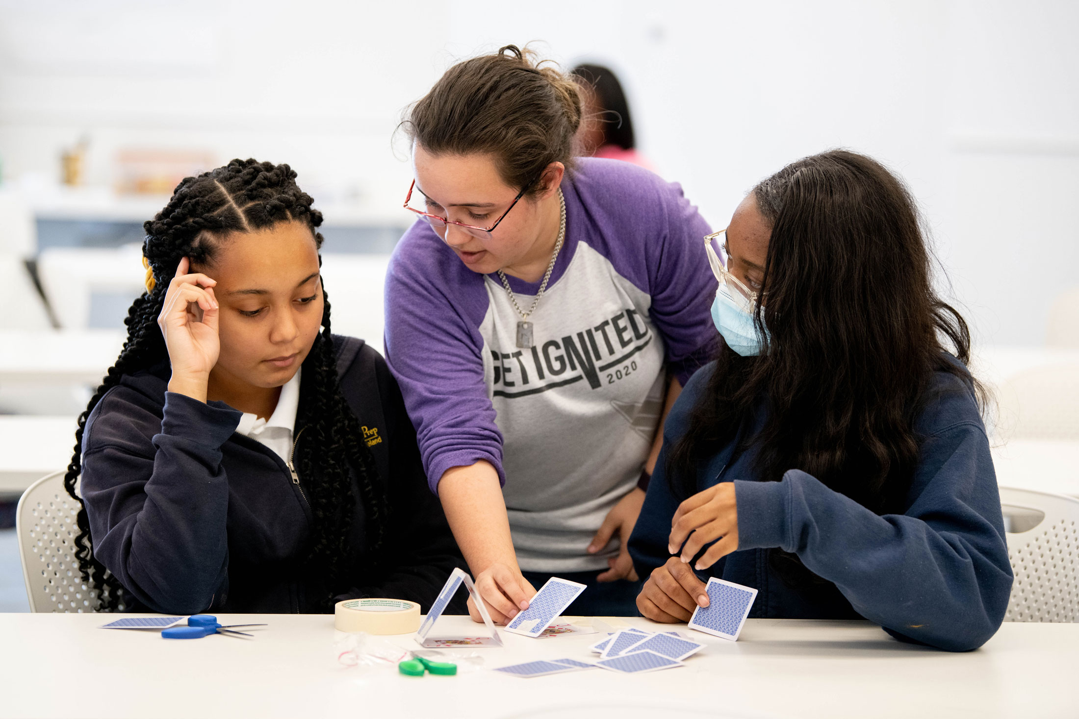 Eighth grade students Chrisette Jones, left, and Mariyah Jones receive direction from a Florida Polytechnic University student 