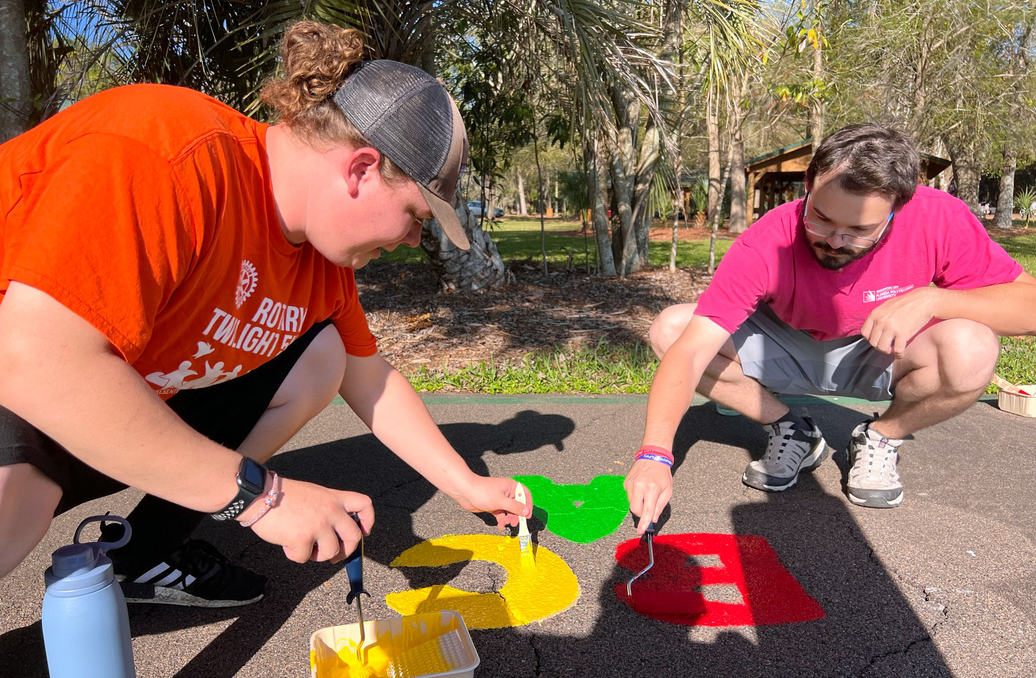 Two students volunteer to paint a trail for Give a Saturday.