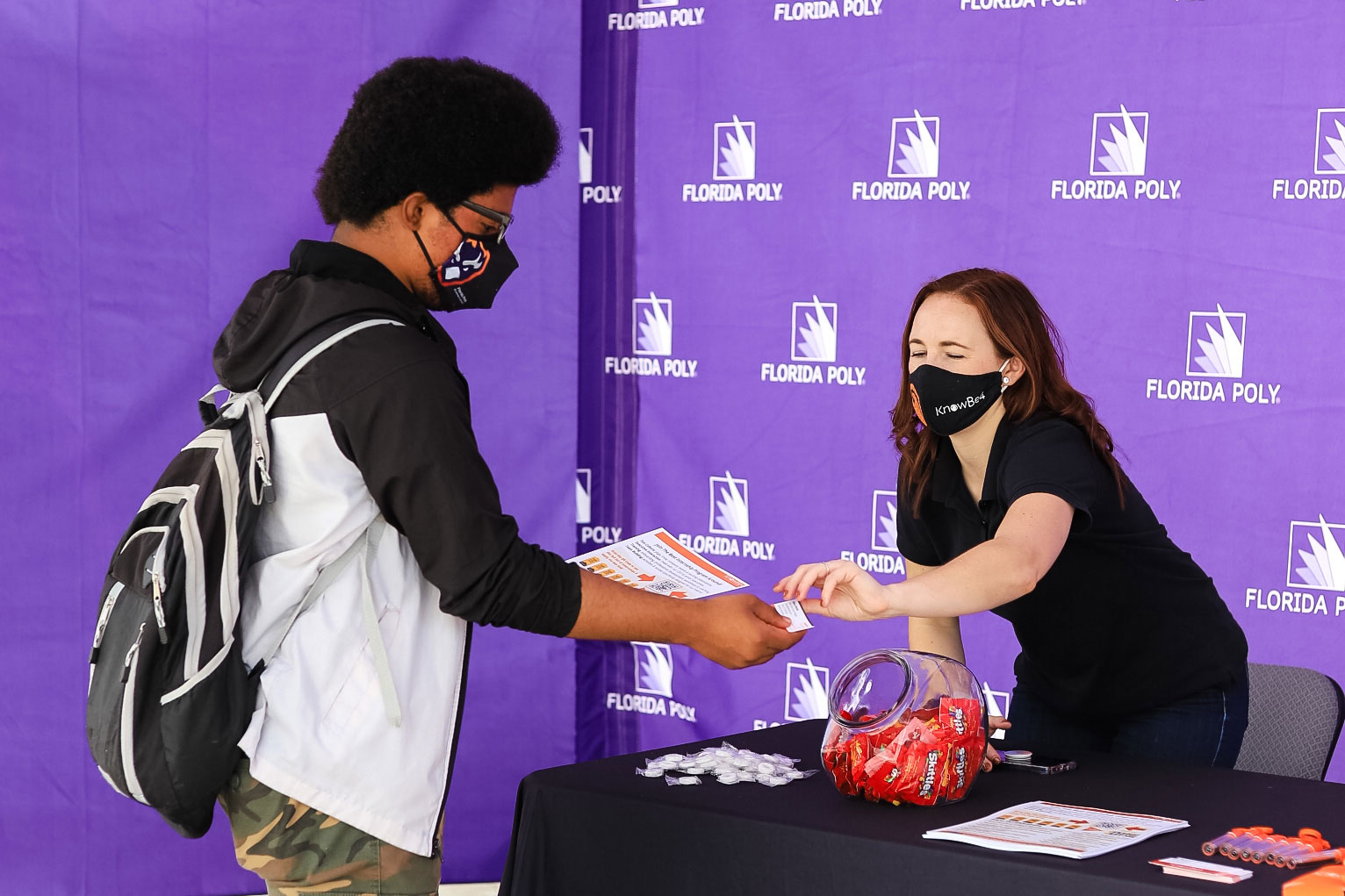 A Florida Polytechnic University student receives informational material from a representative of cybersecurity company KnowBe4 during the company’s sponsored day on campus.