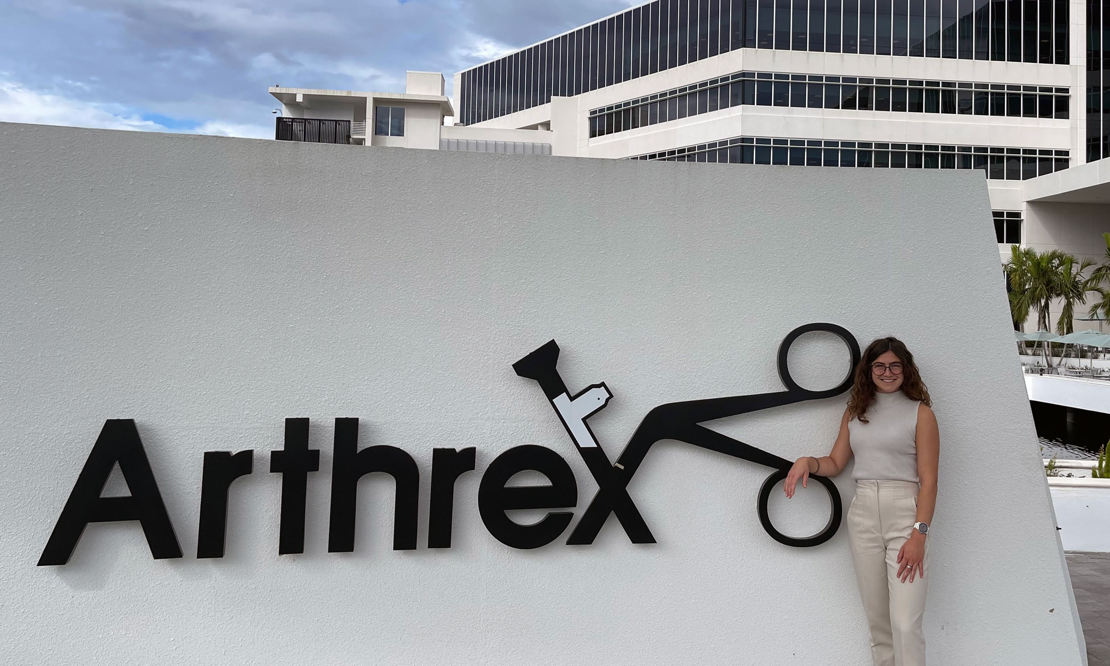 Chelsea Reeves stands with the Arthrex sign.