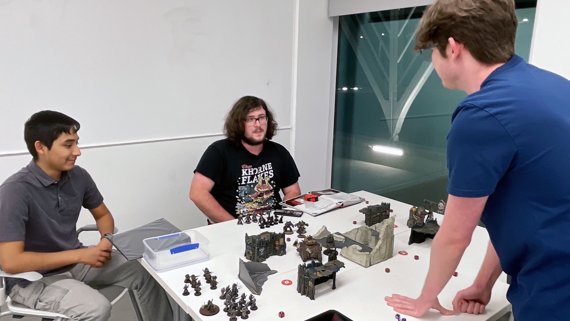 Students Brandon Camacho (left), John Demonbrun, and Jack Rodriguez play Warhammer 40,000 during a recent meeting of the Tabletop Club.