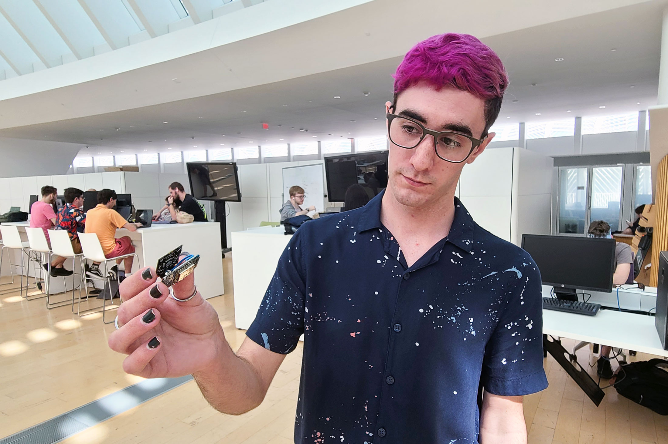 Timothy Nolan, a senior majoring in mechanical engineering, holds the internal workings of the hotel room occupancy sensor his capstone design team is creating for nationwide managed IT services provider Corserva.