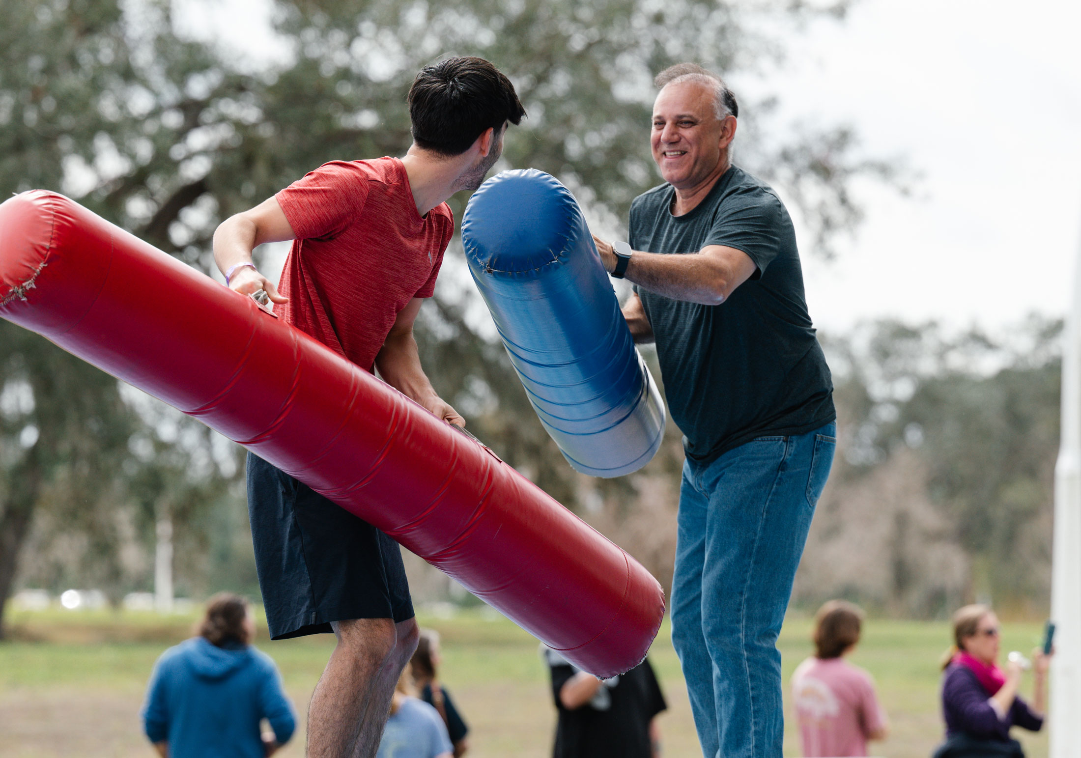 Two people competing in a fun jousting event.