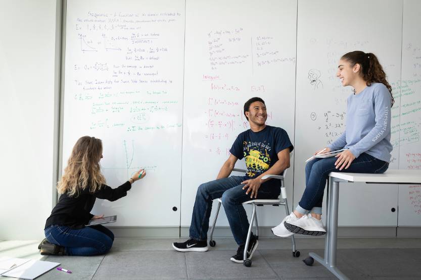 Students talking in a classroom.