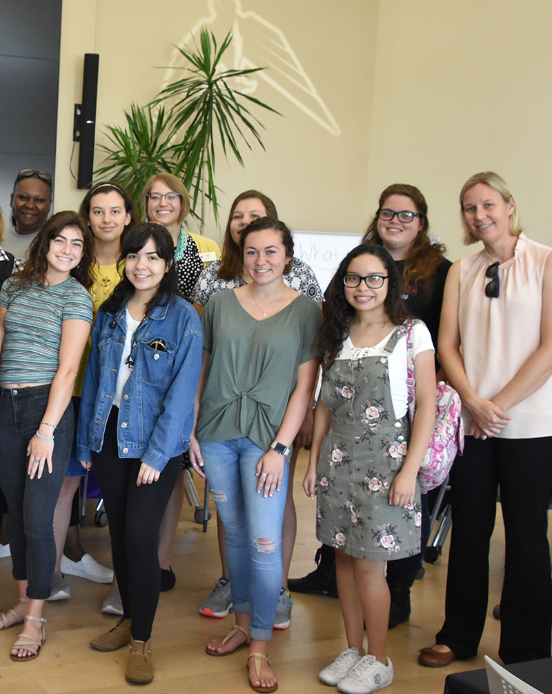 female students and faculty pose for group photo