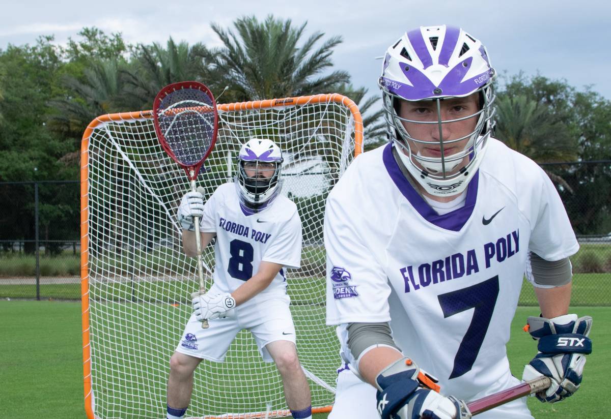 two male lacrosse players in front of goal