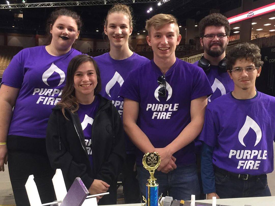 students smiling with trophy