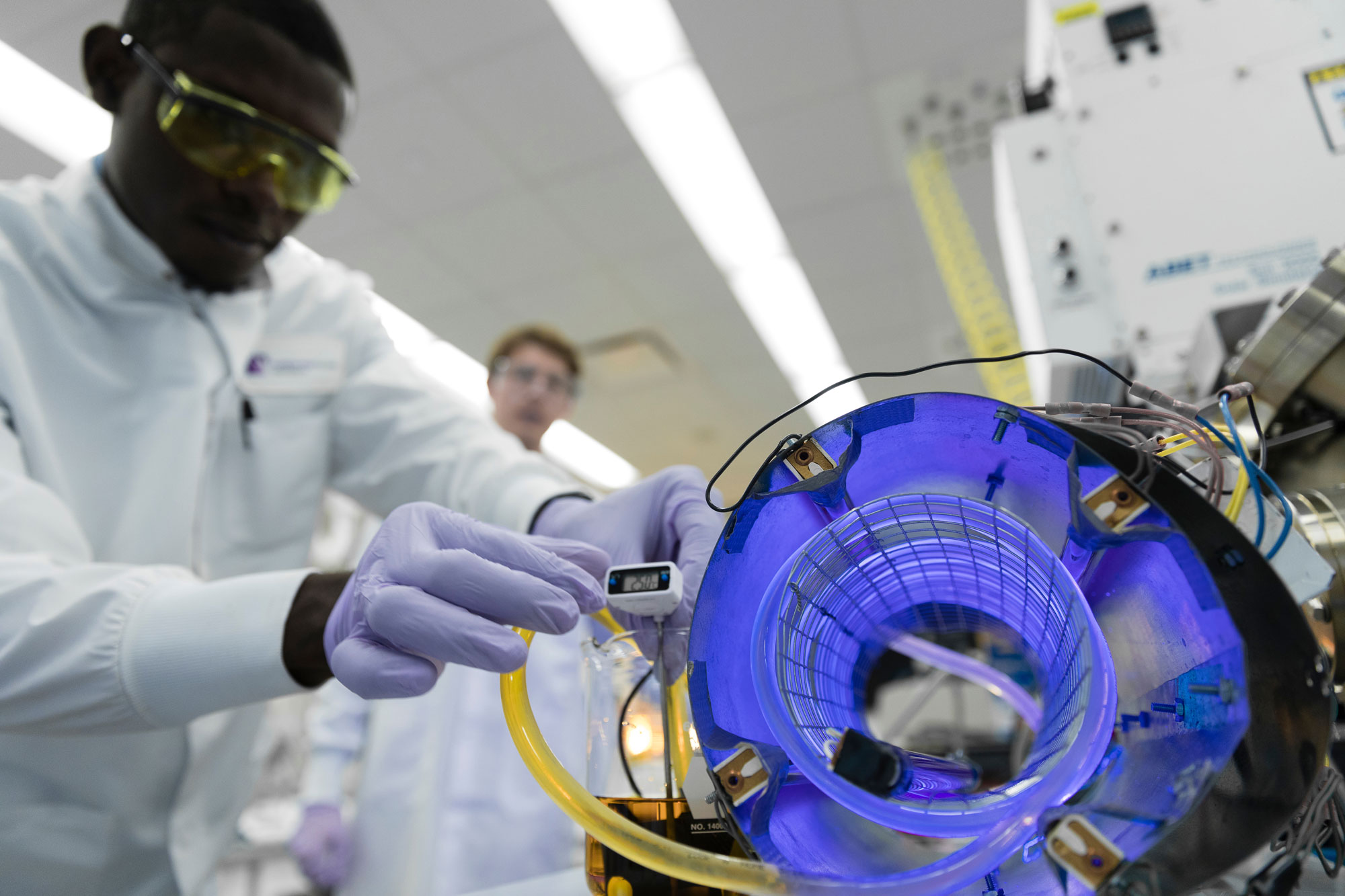 Dark skinned male working in lab setting.