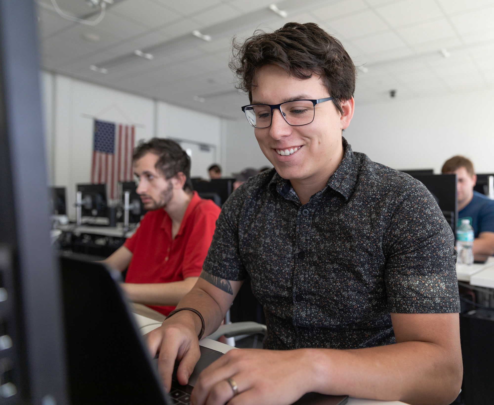 Light skinned male looking at a computer.