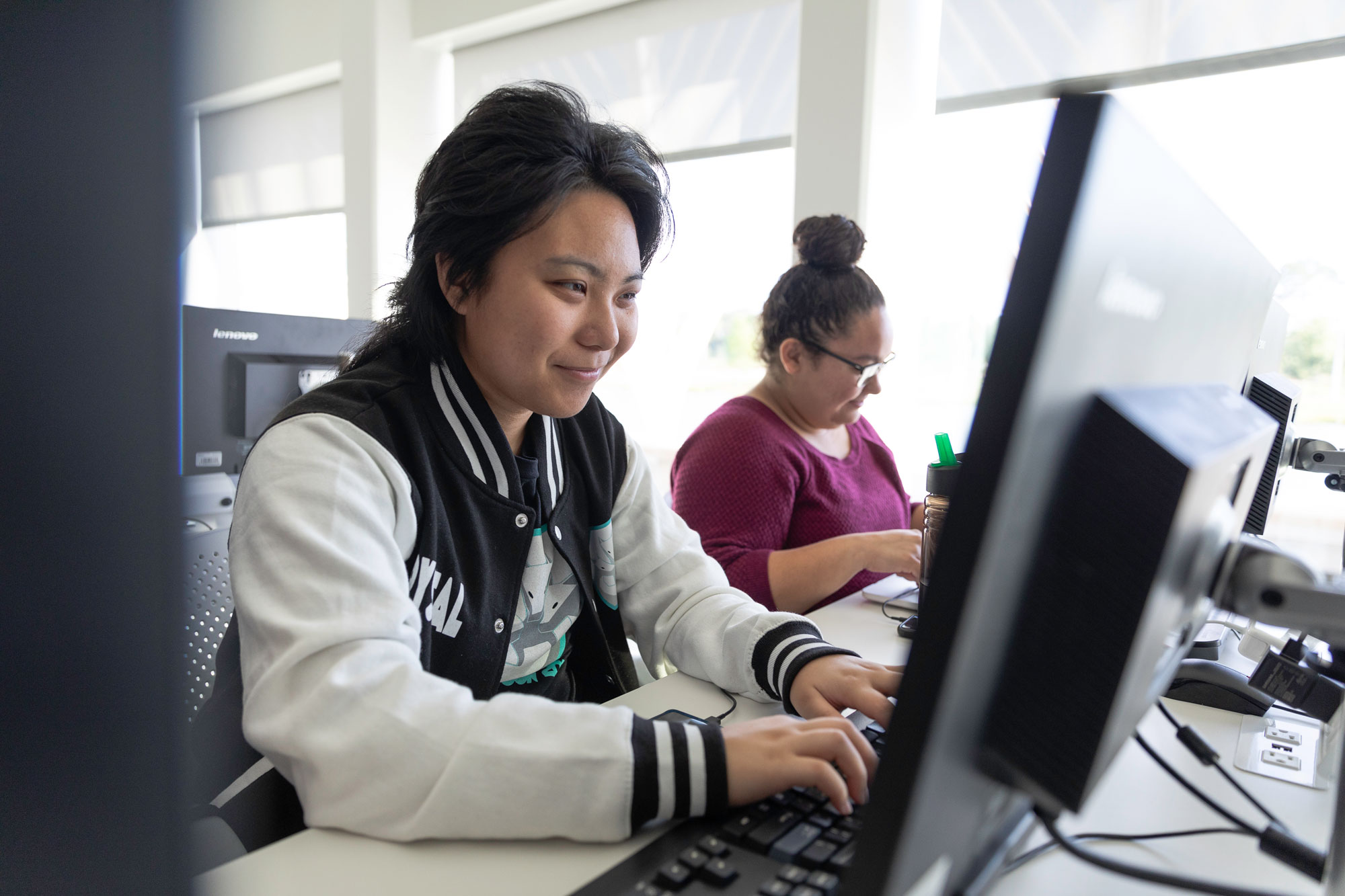 Light skinned female looking at a computer.