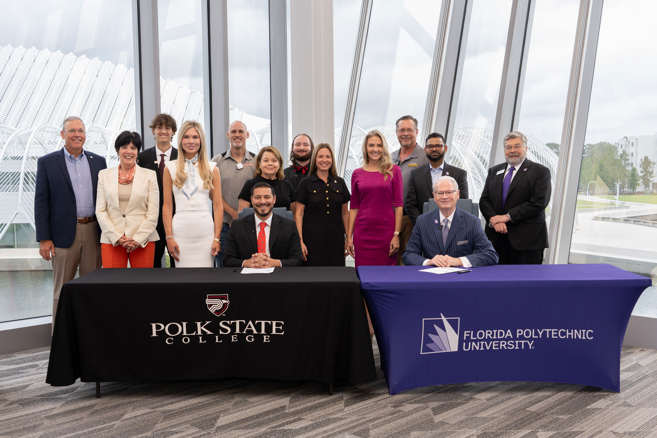 Polk State College President Anastasios Kamoutsas and Florida Polytechnic University President Devin Stephenson sign an expanded transfer agreement July 30 at Florida Poly’s Barnett Applied Research Center, joined by legislators, trustees, industry representatives and students.