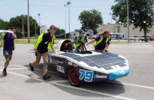 Phoenix Racing team members escort their solar race car Spark MK 2.5 during the cross-country race.