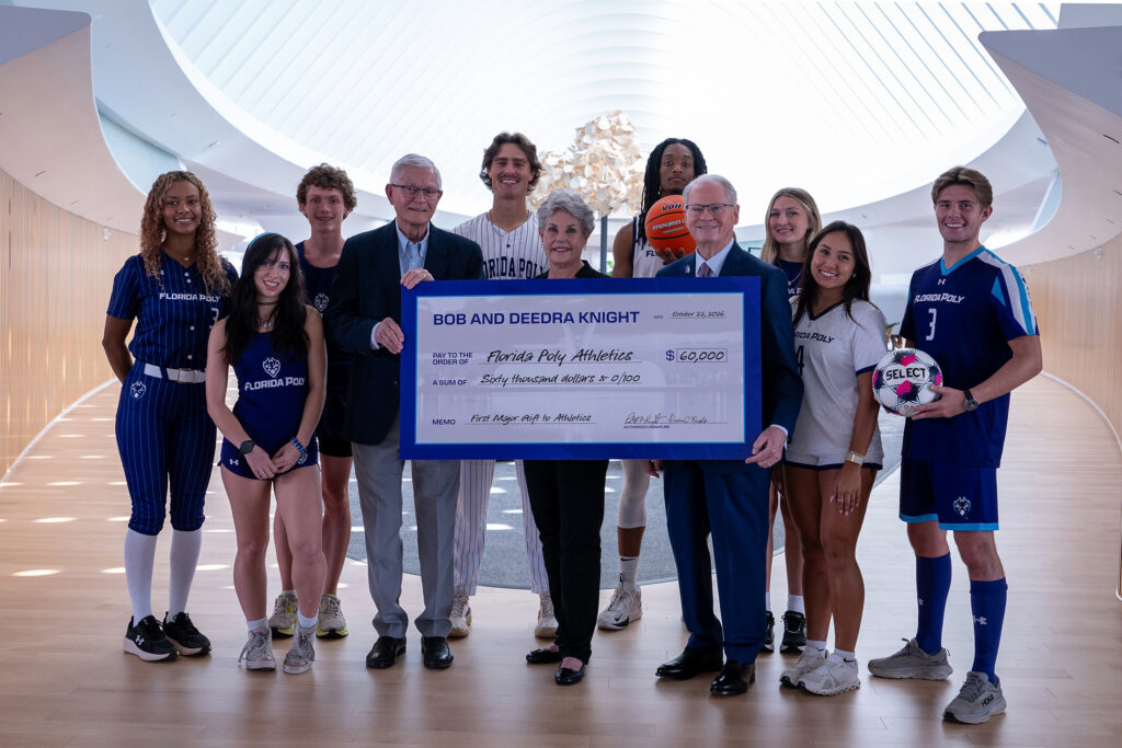 From left, Bob Knight, Deedra Knight and Dr. Devin Stephenson, Florida Polytechnic University’s president, pose with student-athletes in celebration of the Knight family's historic first gift to Florida Poly Athletics.