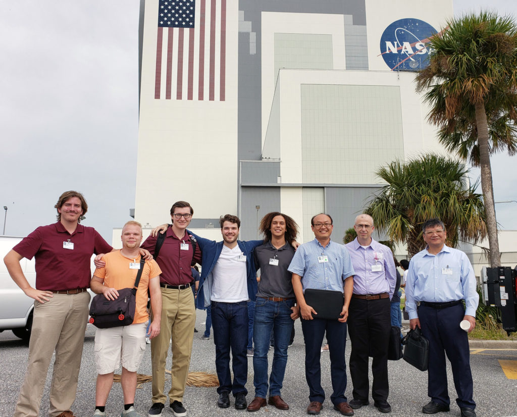 Group of students and faculty outside of NASA space center building.