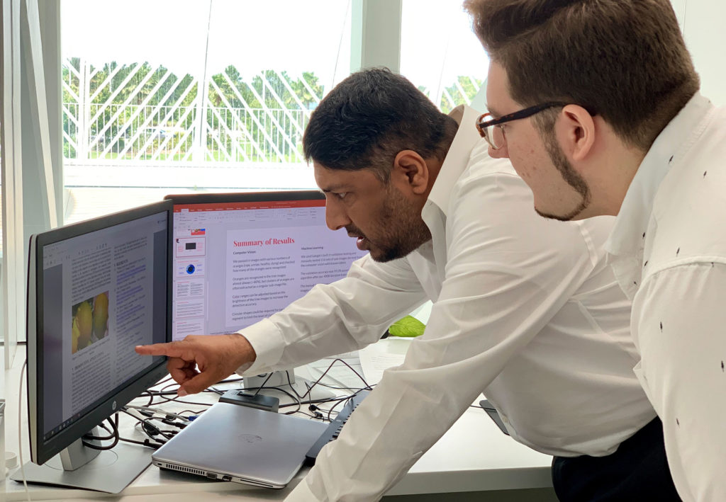 Florida Poly professor and student looking over research at computer.