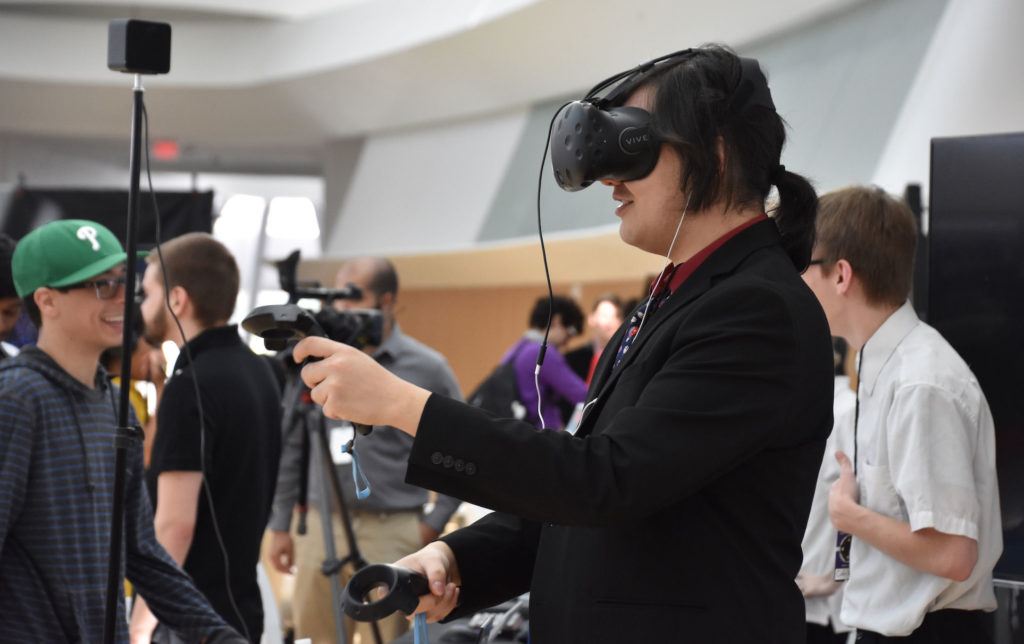 Florida Poly student holding up VR controllers at Game EXPO
