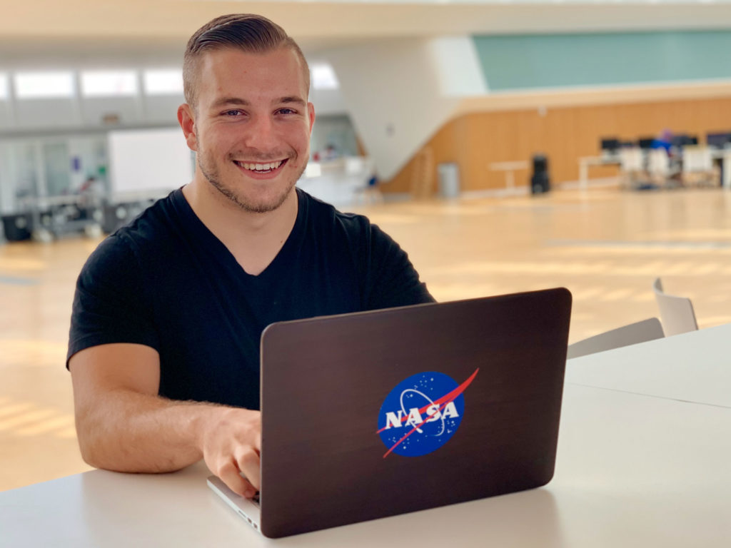 Florida Poly student in front of lab top computer.