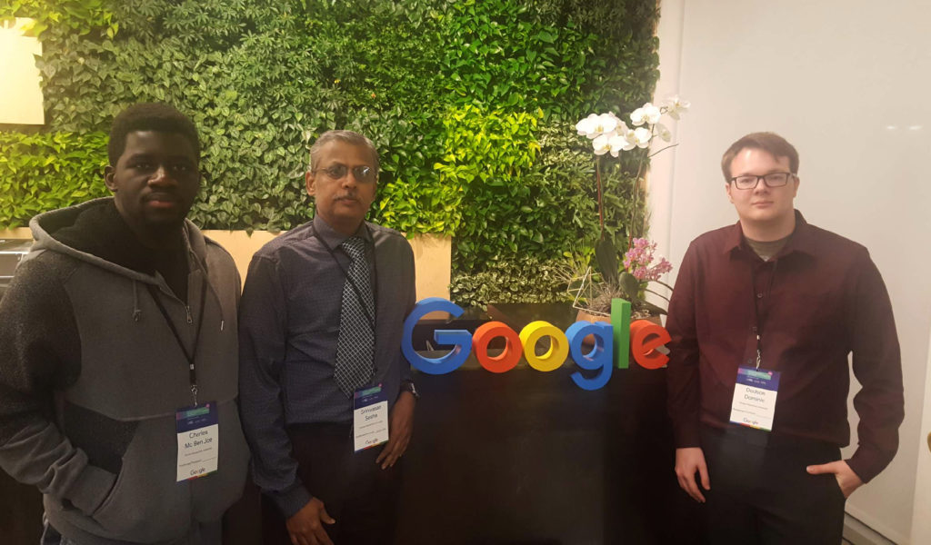 Two students Florida Poly students and faculty stand in front of Google sign.