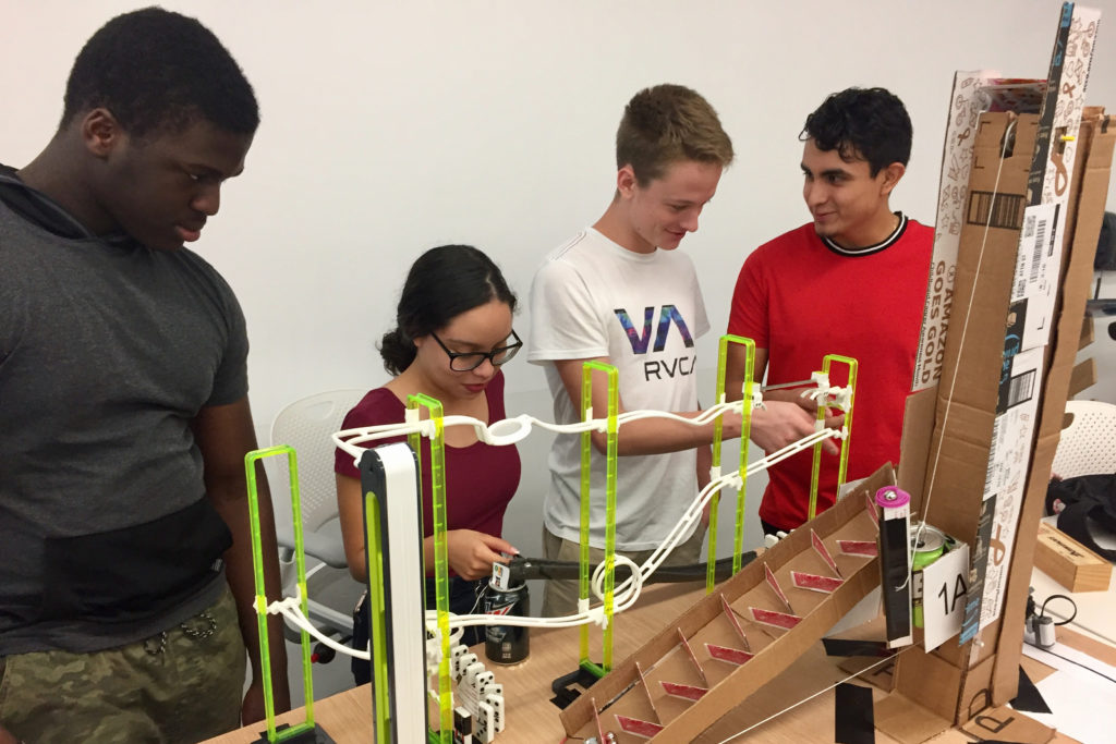 Four Florida Poly students test their Rube Goldberg machine