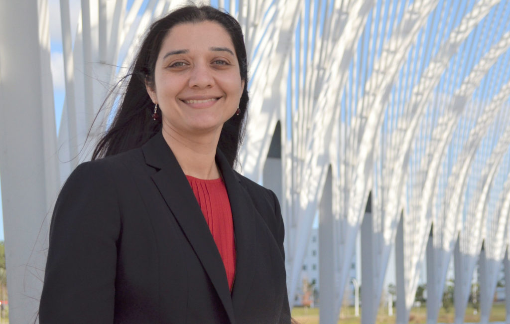 Female professor standing outside of Innovation, Science, and Technology (IST) Building at Florida Polytechnic University.