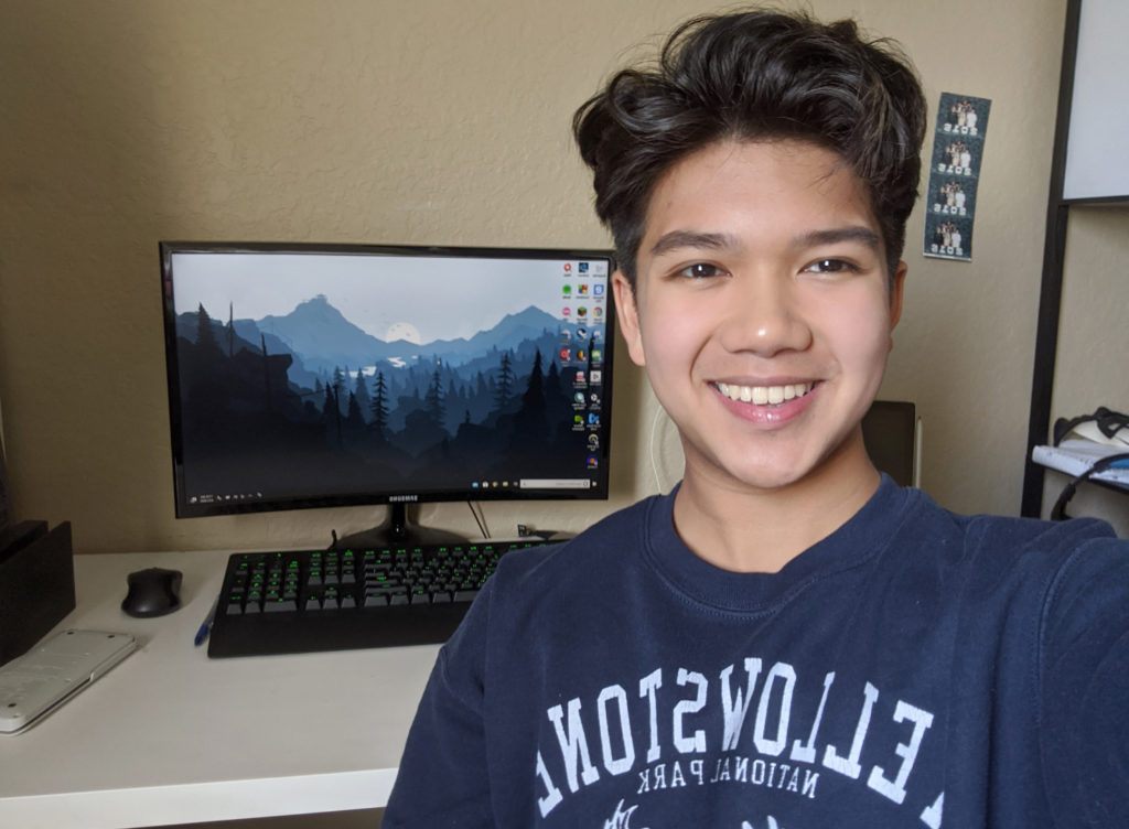 Light skinned male in front of a computer.