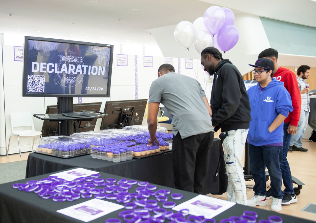 Degree Declaration day graphic on tv with people at a table.