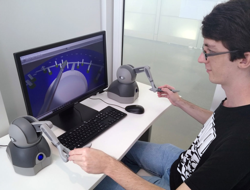 Light skinned male sitting in front of a computer.
