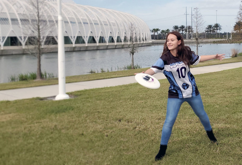 Female student throwing frisbee.