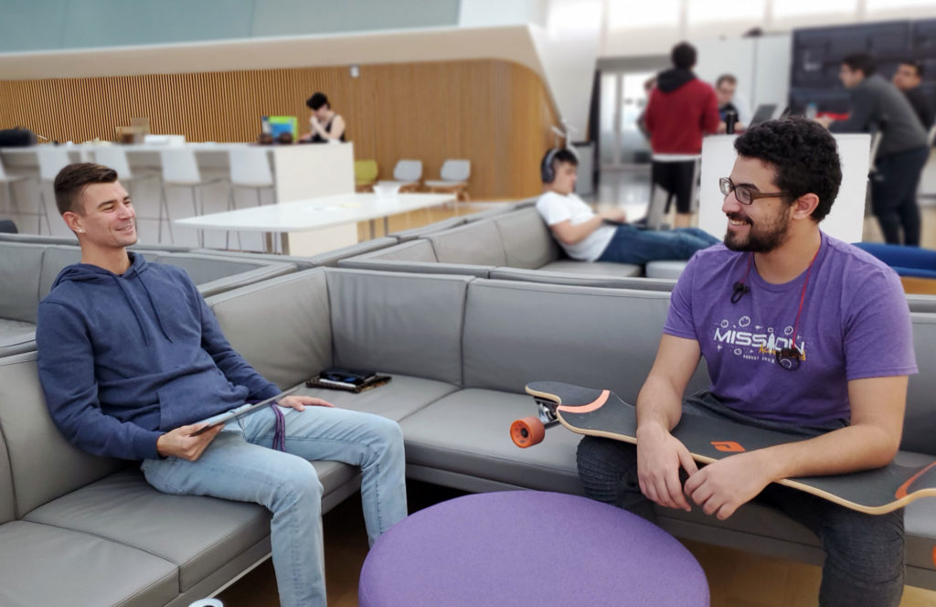 Two male students sitting on couch in IST Commons area.