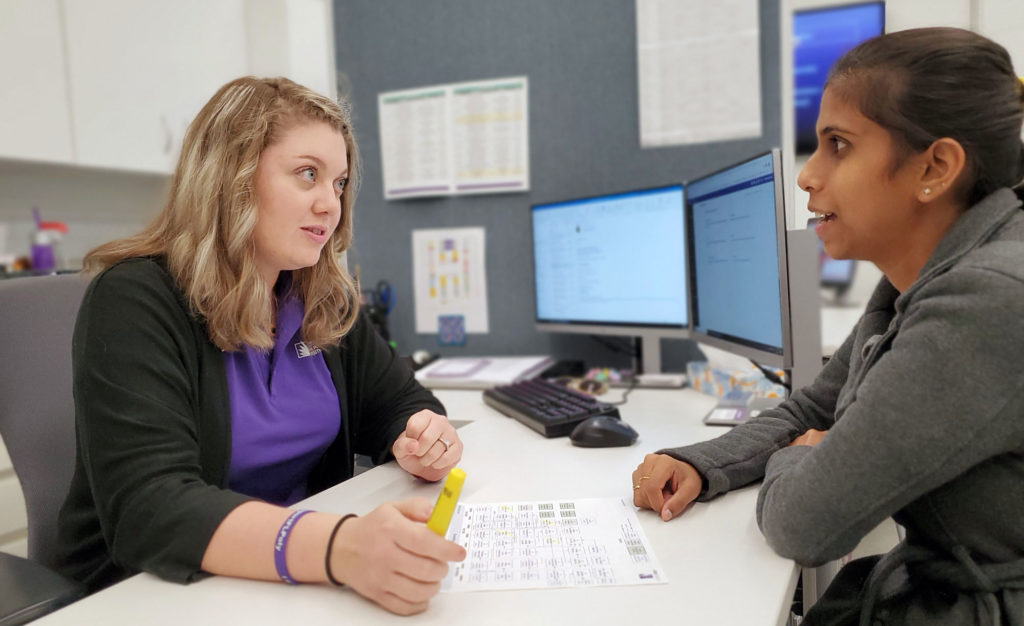 Two women sitting at a desk.